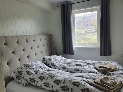 łóżko w sypialni z oknem w obiekcie Molden 1 - med Jacuzzi! w mieście Luster