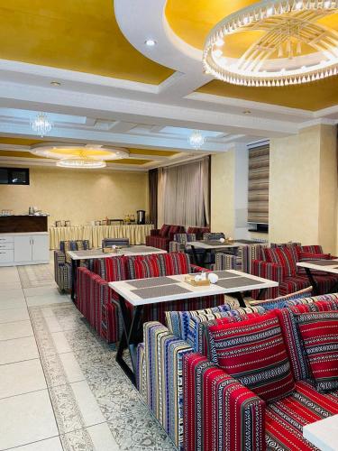 Un comedor con mesas y sillas en un restaurante. en KOCHEVNIK NOMAD hotel, en Bishkek