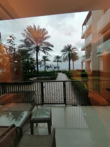 a balcony with a view of the ocean and palm trees at Two Bedrooms Apartment at Address Residence Fujairah in Sharm