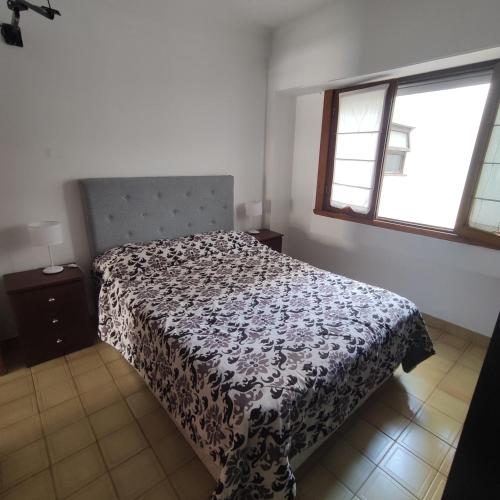 1 dormitorio con 1 cama con colcha en blanco y negro en LUAMAR en Mar del Plata