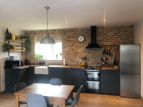 a kitchen with a table and a brick wall at Sandyhill Guest House - Westport in Westport