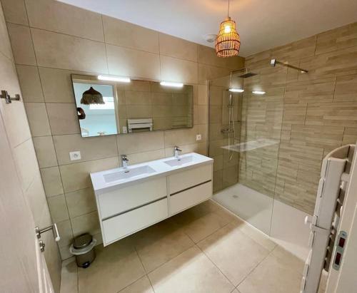 une salle de bain avec un lavabo, une douche et un miroir dans l'établissement Paillote Perchée à 180 ° sur la mer, à Ajaccio