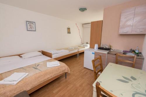 Habitación pequeña con 2 camas y cocina en Guest House Maria, en Međugorje
