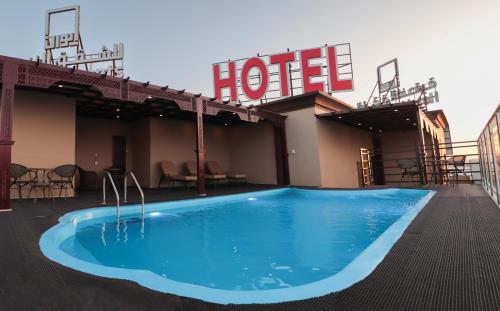 a swimming pool in front of a hotel at Ewann Hotel Apartments in Nizwa