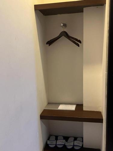 a walk in closet with a shelf and some shoes at Ayla City Hotel in Sorong