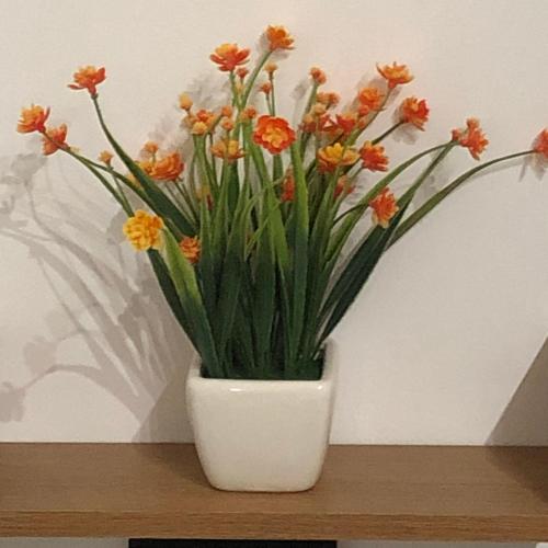 a white vase filled with orange flowers on a shelf at Casa Sipontina in Barletta