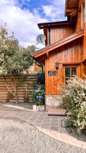 un edificio de madera con una cámara de seguridad en el lateral en El Abedul Cabaña en La Cascada, SMA en San Martín de los Andes