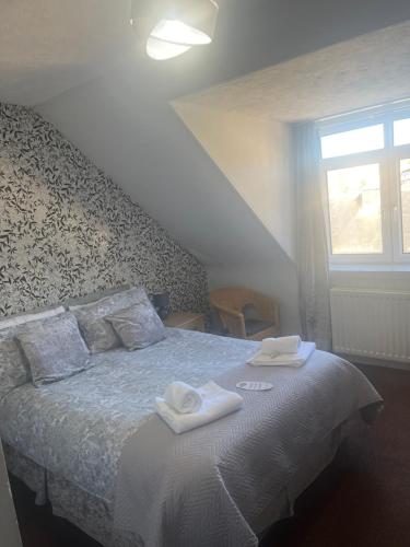 a bedroom with a bed with two towels on it at DunMoore Guesthouse in Oban
