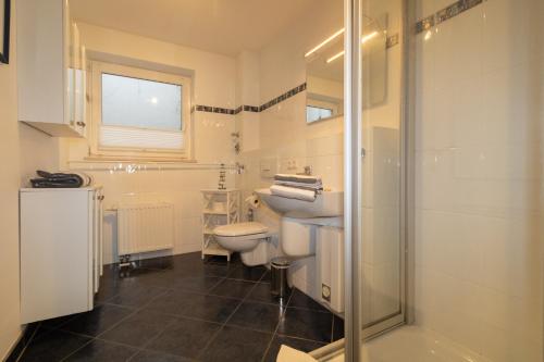 ein Bad mit einem WC, einem Waschbecken und einer Dusche in der Unterkunft Ferienwohnung Frahm in Hörnum