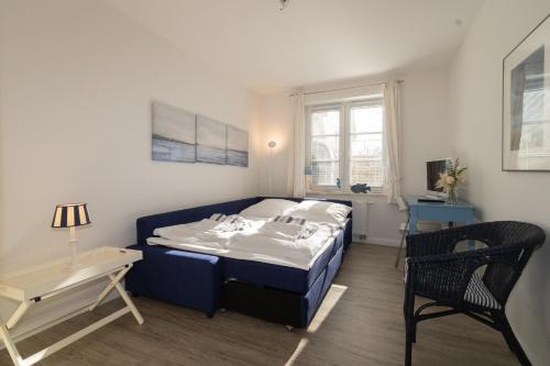 a bedroom with a bed and a table and a chair at Ferienwohnung Frahm in Hörnum