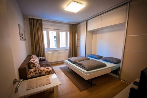 Zimmer mit einem Bett, einem Stuhl und einem Spiegel in der Unterkunft Apartman Omega in Sarajevo