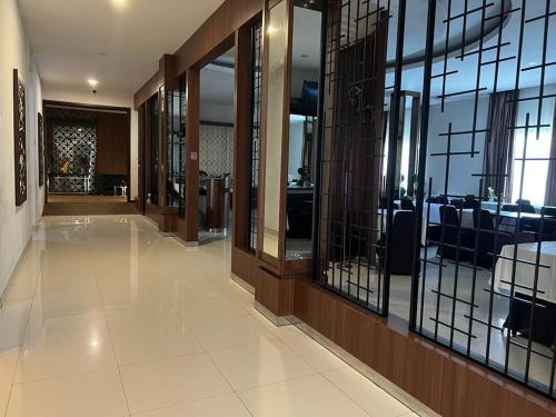 a hallway with glass doors and a dining room at Ayla City Hotel in Sorong