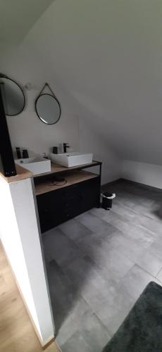 une pièce blanche avec un lavabo et un miroir dans l'établissement le Nid Douillet, à Chènehutte-les-Tuffeaux