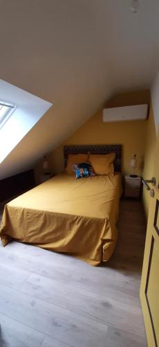 una camera da letto con un letto e un piumone giallo di le Nid Douillet a Chènehutte-les-Tuffeaux