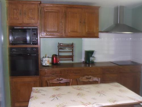 a kitchen with wooden cabinets and a table in it at gite bertry 