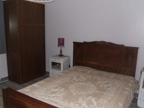 a bedroom with a bed and a table with a lamp at gite bertry 