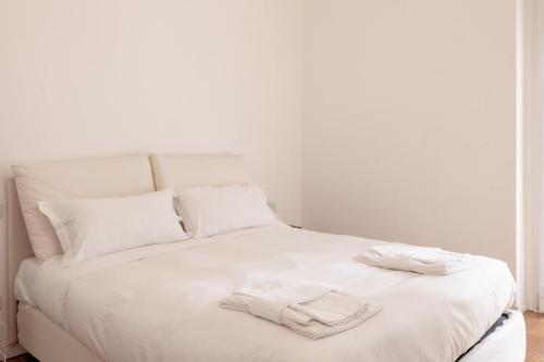 - un lit blanc avec 2 serviettes blanches dans l'établissement BnButler - Casa Lario - Isola District, à Milan