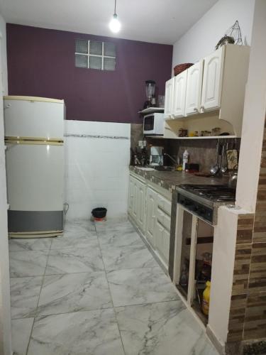 a kitchen with white appliances and purple walls at Casa Isa in Ezeiza