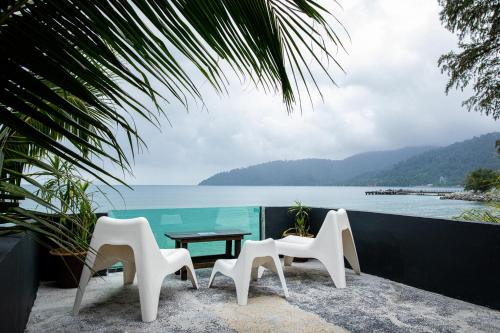 cztery krzesła i stół z widokiem na ocean w obiekcie Tioman Cabana Bed & Breakfast w mieście Tioman