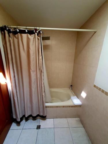 a bathroom with a shower curtain and a bath tub at Apartamento Aeropuerto La Aurora Guatemala in Guatemala