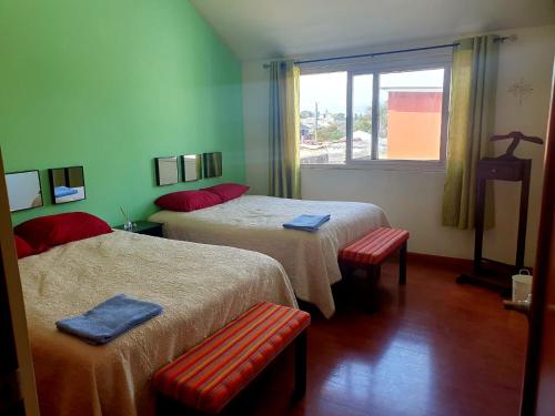 a hotel room with two beds and a window at Apartamento Aeropuerto La Aurora Guatemala in Guatemala