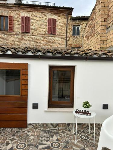 a white house with a patio with a door and a table at CASA GAH in Ripatransone