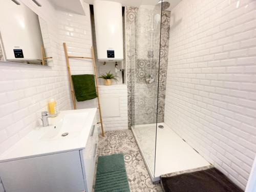 une salle de bain blanche avec une douche et un lavabo dans l'établissement Superbe appartement, 3 chambres, gare St Charles, à Marseille