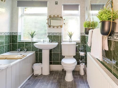 La salle de bains est pourvue de toilettes, d'un lavabo et d'une baignoire. dans l'établissement The Saddlers Cottage, à East Boldon