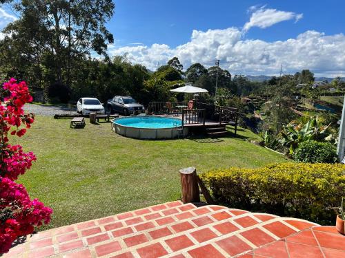 a yard with a pool and a picnic table and a car at Finca Alejandria in Guatapé