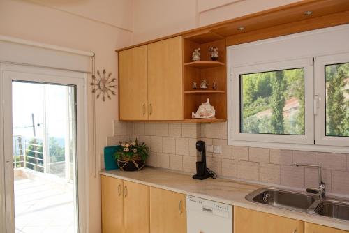 eine Küche mit einem Waschbecken und einem Fenster in der Unterkunft Lila's Villa in Nerotriviá