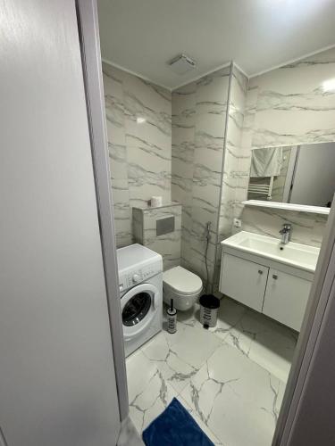 a white bathroom with a washing machine and a sink at New Gudauri, Hotel Peak in Gudauri
