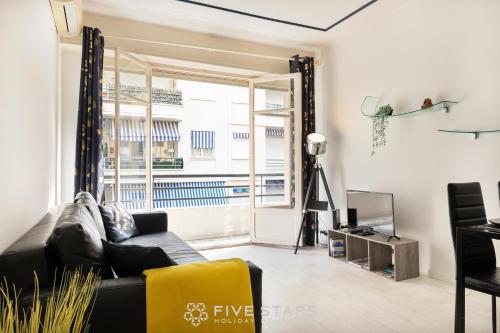 un salon avec un canapé et une fenêtre dans l'établissement Suite Reine Marie FSHH, à Nice