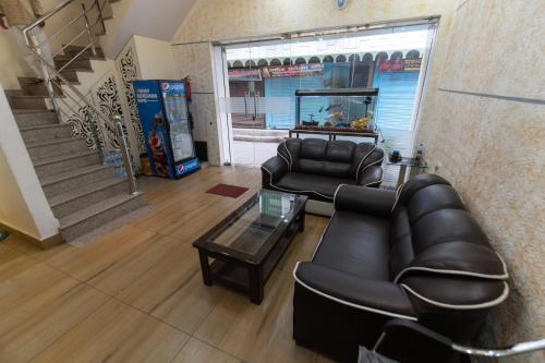 a salon with two leather chairs and a table and stairs at The Century Plaza Hotel in Varanasi