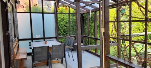 Cudodomek na Mazurach w Woszczelach koło Ełku في إوك: شاشة في الشرفة مع وجود طاولة وكراسي