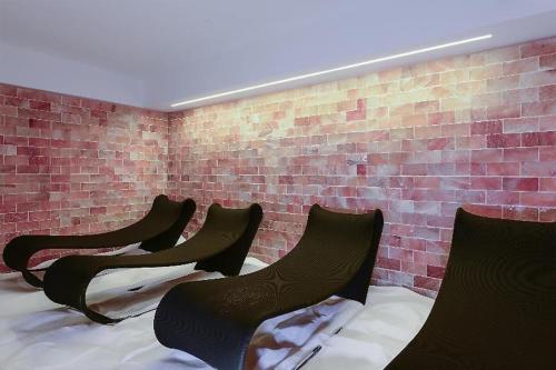 a row of chairs in a room with a brick wall at Seven Park Hotel Lake Como - Adults Only in Colico