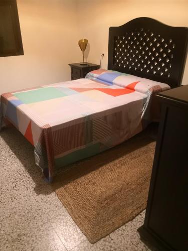 a bed with a colorful quilt on it in a room at Finca La Pimienta in Pizarra