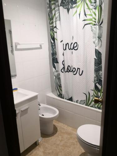 a bathroom with a toilet and a shower curtain at Finca La Pimienta in Pizarra