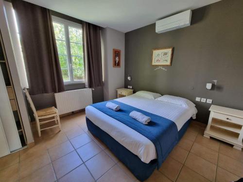 1 dormitorio con 1 cama grande con manta azul en LA RECREATION _ Ancienne école de 1850 rénovée en maison d'hôtes, en Missillac