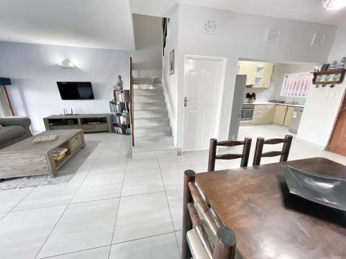 a living room with a couch and a table at Anchored Inn II - A Slice of Heaven in Beautiful Scottburgh in Scottburgh