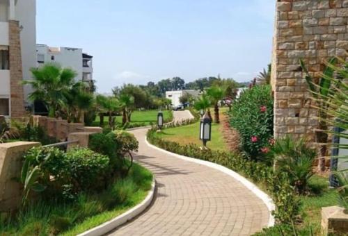 a brick walkway in a park next to a building at Playa Del Pacha, marina smir in M'diq