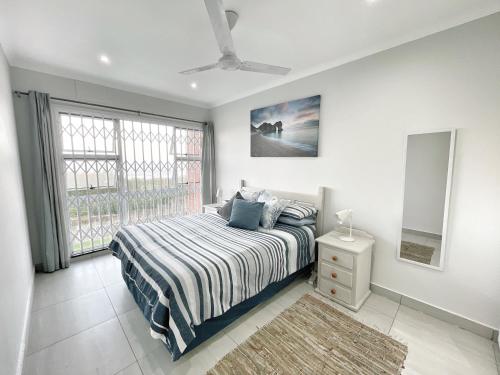 a bedroom with a bed and a window at Anchored Inn II - A Slice of Heaven in Beautiful Scottburgh in Scottburgh