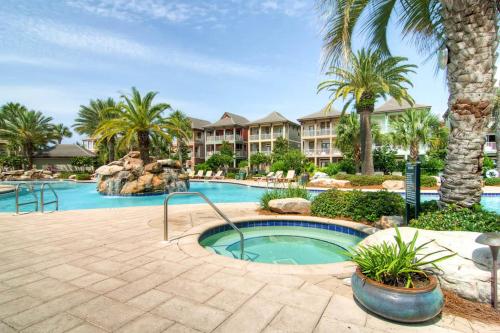 a resort pool with a hot tub and palm trees at House of Kings in Destin