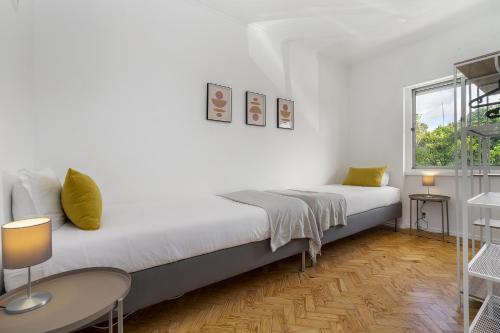 a white bedroom with a bed and a window at WHome Peaceful Algés Family Home away from City Noise in Lisbon