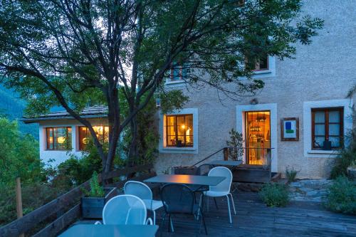 un patio avec une table et des chaises devant une maison dans l'établissement Maison Cimes, aux Orres