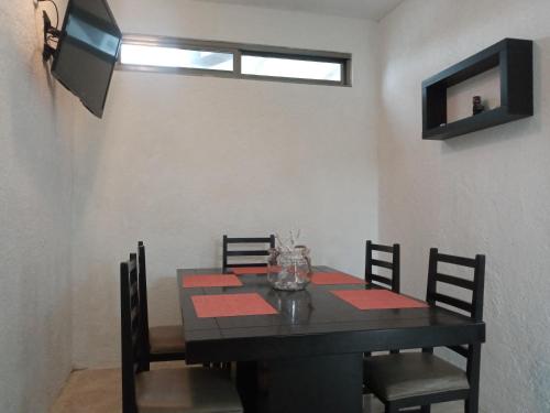a dining room with a black table and chairs at El Mirador Holbox in Holbox Island