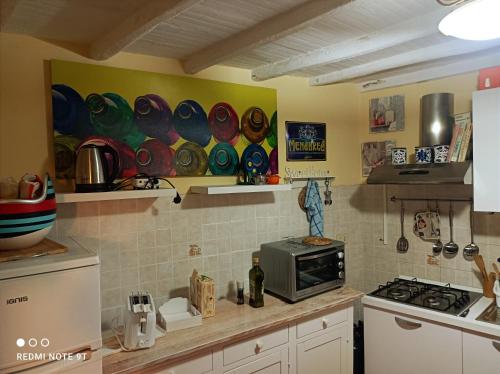 een keuken met een aanrecht met een magnetron bij Accogliente casa in pietra in borgo medievale in Serra Pistoiese