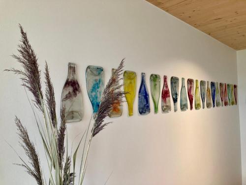 a row of different colored vases on a wall at MoselHoch in Klüsserath