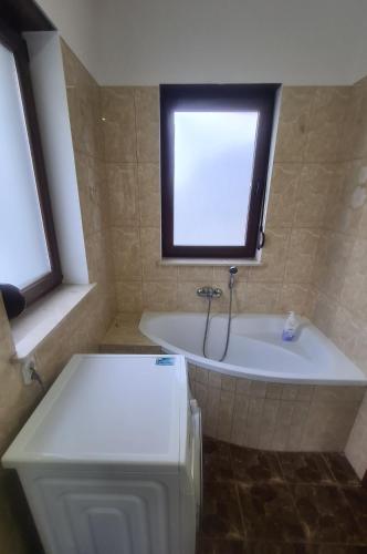 a bathroom with a bath tub and a window at Dom pod Wroclawiem19 in Domasław
