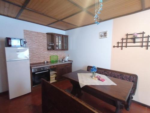 Il comprend une cuisine équipée d'une table et d'un réfrigérateur blanc. dans l'établissement Apartma, à Selnica ob Dravi