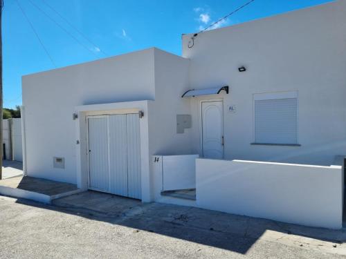 a white building with two doors on the side at Natura House in Aveiro